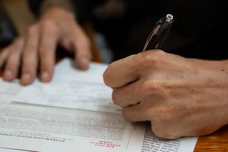 Person signing bail bond paperwork at a desk